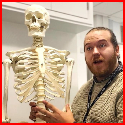 Dr Ross Davey stood next to a skeleton